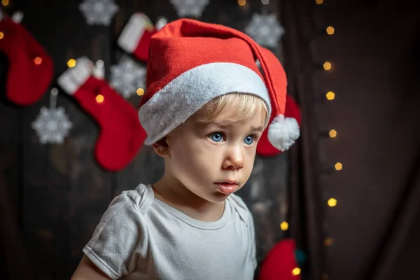 Bebeğin ilk Noel 'i. Noel süslemeleriyle çevrili sevimli bir erkek bebek..