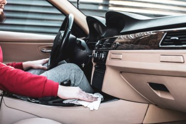 Genç bir çocuk arabasını temizliyor. Arabasıyla ilgilenen bir çocuk..