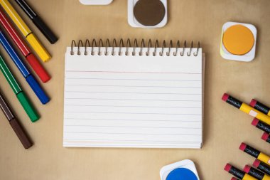 An empty notebook surrounded with school equipments. Empty notebook. Empty space.