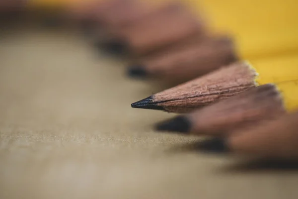 Lot of pencils on a wooden background. Yellow pencils.