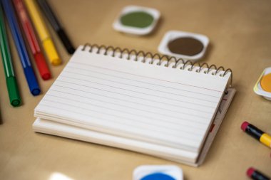 An empty notebook surrounded with school equipments. Empty notebook. Empty space.