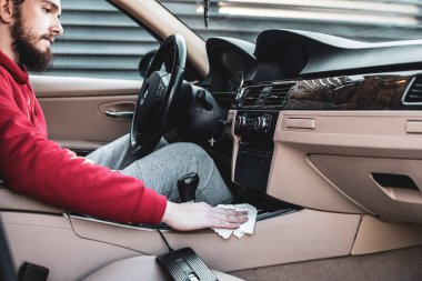 Genç bir çocuk arabasını temizliyor. Arabasıyla ilgilenen bir çocuk..