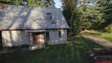 Ormandaki çiftçi evinin yanındaki eski kırmızı traktör.