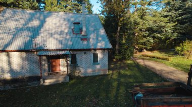 Ormandaki çiftçi evinin yanındaki eski kırmızı traktör.