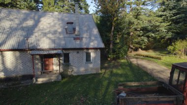 Ormandaki çiftçi evinin yanındaki eski kırmızı traktör.