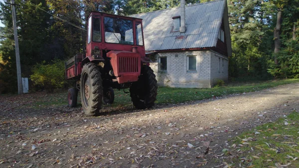 Stary Czerwony Ciągnik Pobliżu Domu Rolnika Lesie — Zdjęcie stockowe