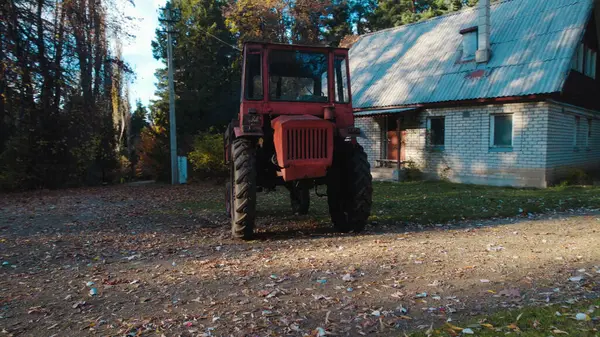 森林里靠近农舍的红色旧拖拉机 — 图库照片