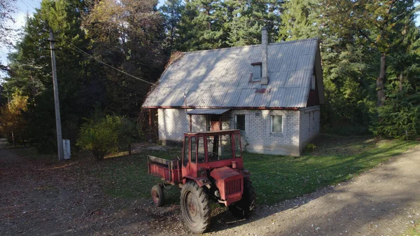 Starý Červený Traktor Blízkosti Statku Lese — Stock fotografie