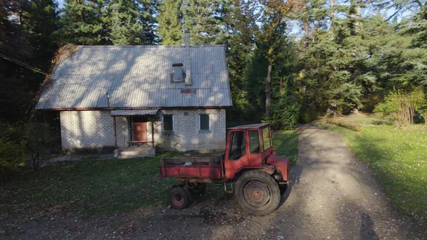 Tractor Roșu Vechi Lângă Casa Agricultorilor Din Pădure — Fotografie, imagine de stoc