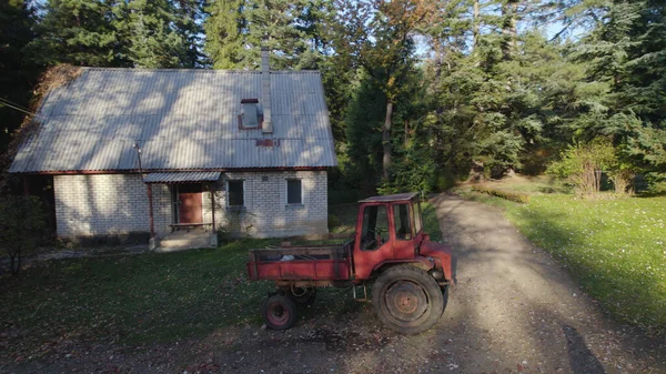 Starý Červený Traktor Blízkosti Statku Lese — Stock fotografie