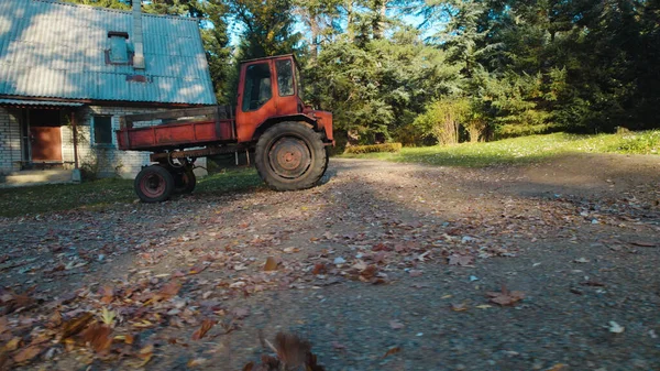 森の農家の近くの古い赤いトラクター — ストック写真