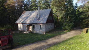 Ormandaki çiftçi evinin yanındaki eski kırmızı traktör.
