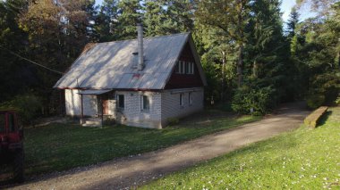 Ormandaki çiftçi evinin yanındaki eski kırmızı traktör.