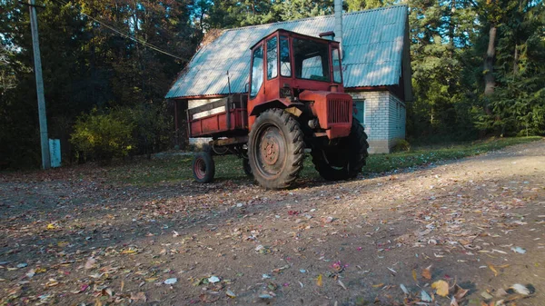 Vanha Punainen Traktori Lähellä Maalaistaloa Metsässä — kuvapankkivalokuva