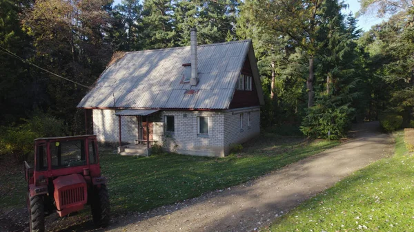 Stary Czerwony Ciągnik Pobliżu Domu Rolnika Lesie — Zdjęcie stockowe