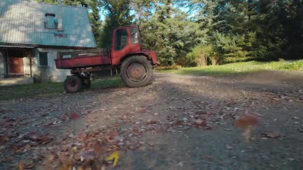 森林里靠近农舍的红色旧拖拉机 — 图库视频影像