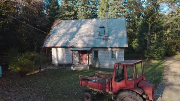 Gammel Rød Traktor Nær Bondehuset Skogen – stockvideo