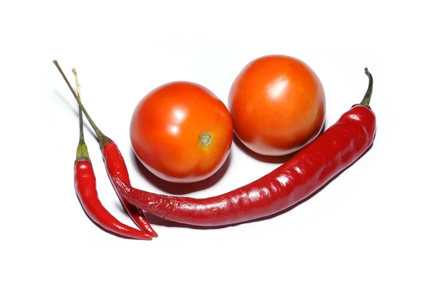 Fresh tomatoes and red hot chilies on white — Stock Photo, Image