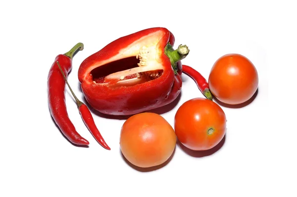 Fresh tomatoes, red hot chilies and red bell pepper cut on white — Stock Photo, Image