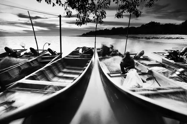 Muelles de pescadores flotando en el agua al atardecer en blanco y negro Imagen de archivo