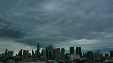 Bulutların zaman akışı karanlık gökyüzü ve bulutlu Bangkok silueti üzerinde ilerliyor ve şehir merkezindeki Bangkok şehrindeki Chan Road Sathorn, Bangkok, Tayland 'daki çatı katında gökdelen..