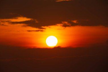 Parlak güneş gökyüzünde parlıyor ve bulutlar akşam vakti