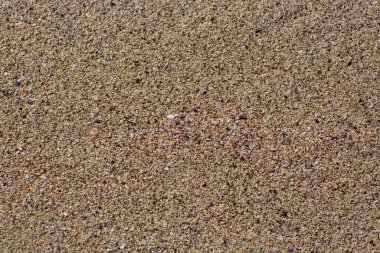 Kumsal kum dokusu. Kum Arkaplanı 'nın güzelliği, duvar kağıdı. Kahverengi kumlu plajın soyut arka planı, üst manzara. Denizin üzerindeki kum alanının tam kare görüntüsü, yakın çekim. Küçük taşların dokusu, çakıl taşı.