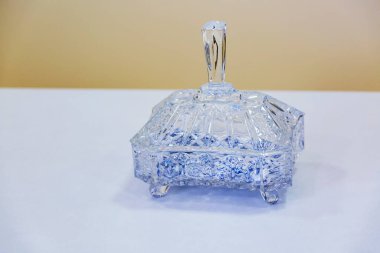 Mutfağın içinde kapağı olan cam vazo dekoru. Zarif dekoratif kristal reçel vazosu. Altın beyazı arka planda hassas kavanoz. İç dekorasyon. Şekerli büyük cam vazo.