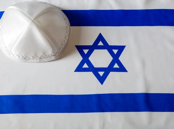 David 'in Yıldızı, İsrail bayrağında Yarmulke Kippa. Arka planda İsrail bayrağı olan Kippah (dini şapka). Sukkot, Şabat, Rosh Hashanah ve Yom Kippur 'un Yahudi Sembolleri. 