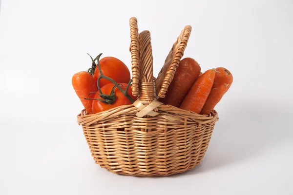 Tomates e cenouras em uma cesta — Fotografia de Stock