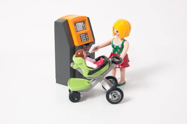 Playmobil moeder en baby en een Geldautomaat Rechtenvrije Stockfoto's