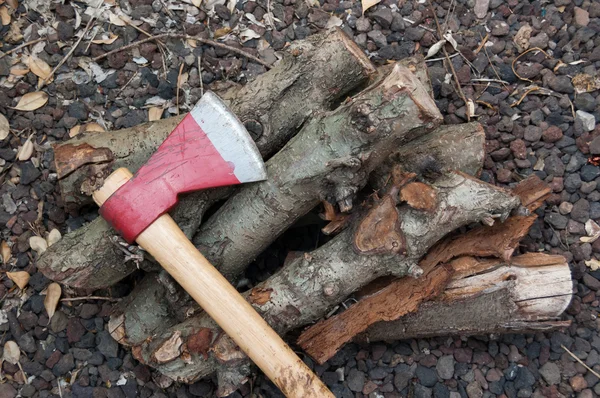 Axe and firewood in the ground — Stock Photo, Image