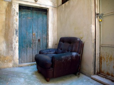 Binanın duvarında eski deri bir sandalye