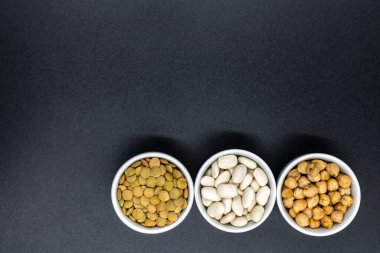 Tahta arka planda siyah bir kasede farklı tipte fındıklar..