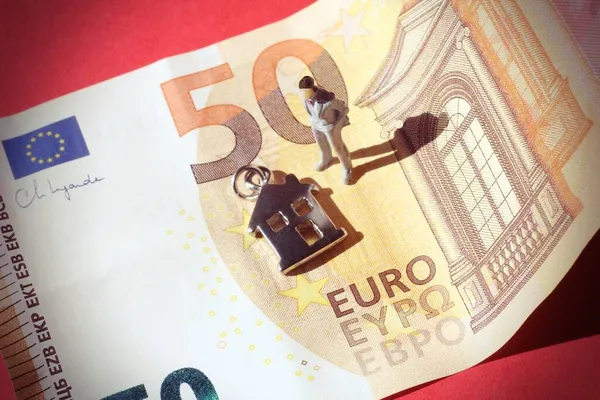 50ユーロ紙幣の中にミニチュアビジネスの男と家のシンボル — ストック写真