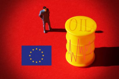 Piyasa grafiği olan bir petrol varilinin önünde minyatür bir iş adamı ve Avrupa Bayrağı, petrol fiyatı kavramı.