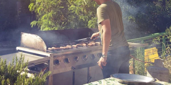 Chico Joven Cocinando Salchichas Sobre Fuego Abierto Mientras Acampa Naturaleza —  Fotos de Stock
