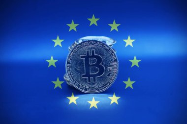 Bitcoin gold coin with a pile as background inside the European Flag. Virtual cryptocurrency concept.