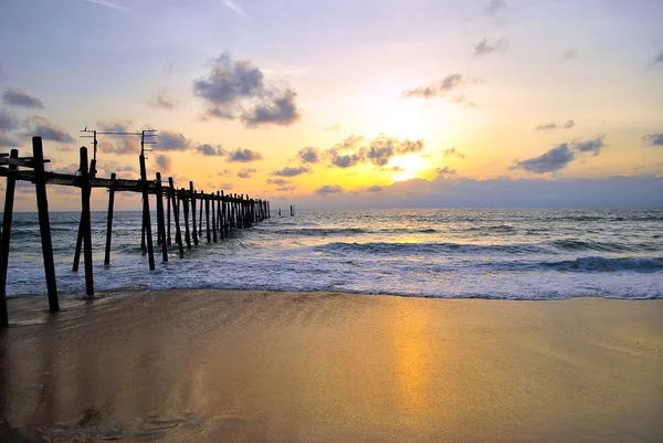 Brug en zonsondergang strand — Stockfoto