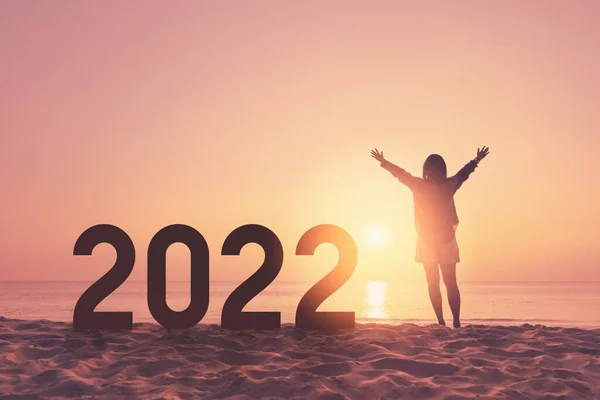 シルエットの女性は 日没の空の抽象的な背景の熱帯ビーチで手を上げて番号2022を上げます お正月や休日のお祝いのコンセプト ヴィンテージトーンフィルターカラースタイル — ストック写真