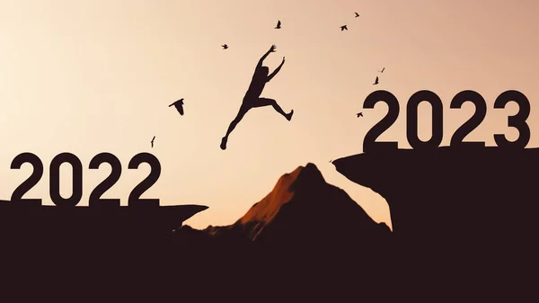 2022年から2023年にかけて崖の間を飛び立つシルエットの男と山頂を飛ぶ鳥 自由の挑戦と旅行冒険の休日の概念 ヴィンテージトーンフィルターエフェクトカラースタイル — ストック写真
