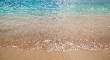 masmavi deniz dalgaları ile sarı kum plaj