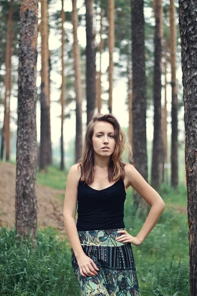 Jonge brunette meisje in kleurrijke rok poseren in het bos — Stockfoto