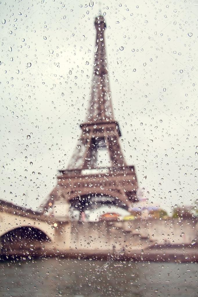 View on the Eiffel Tower through the window with rain drops. France. Paris.
