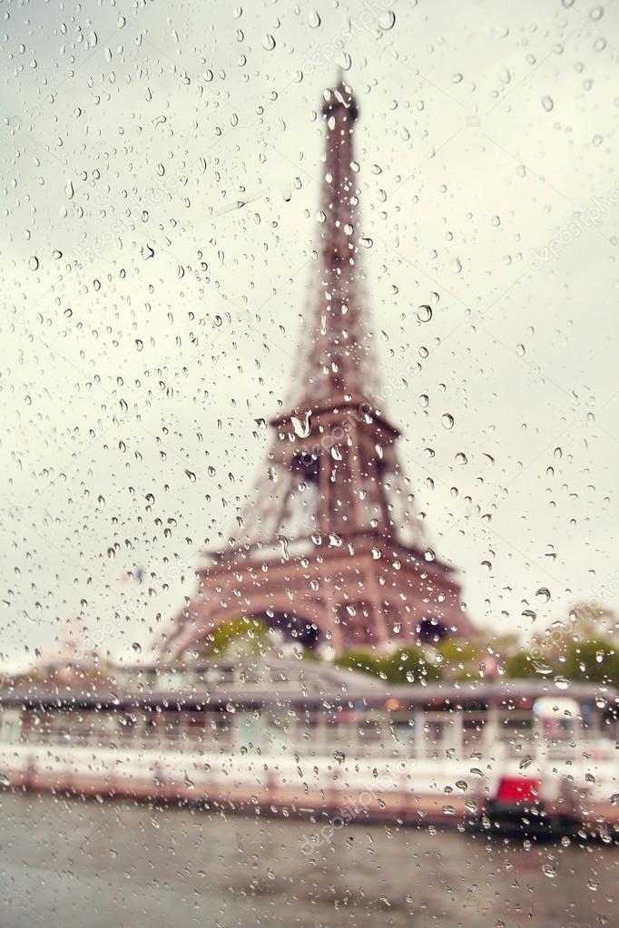 View on the Eiffel Tower through the window with rain drops. France. Paris.