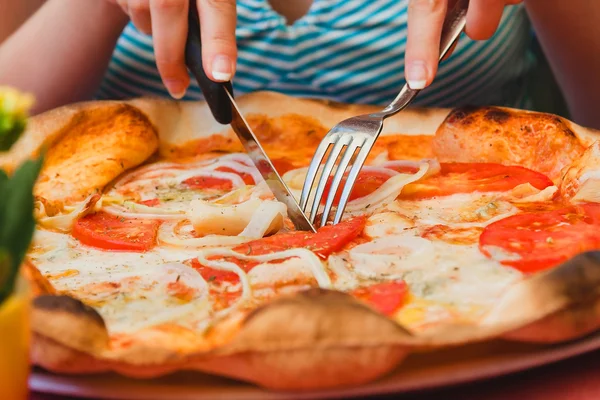 Quella donna mangia la pizza. Chiudi la pizza italiana con pomodoro e formaggio con forchetta e coltello — Foto Stock