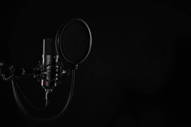 Siyah arka planda izole edilmiş proffesional stüdyo mikrofonu. Podcastlar ve müzik kayıtları.
