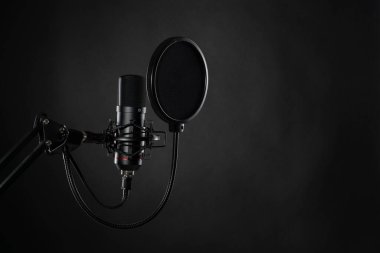 Siyah arka planda izole edilmiş proffesional stüdyo mikrofonu. Podcastlar ve müzik kayıtları.