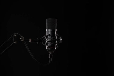 Siyah arka planda izole edilmiş proffesional stüdyo mikrofonu. Podcastlar ve müzik kayıtları.