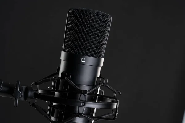 Close up image of professional studio microphone on the black background during singing recording